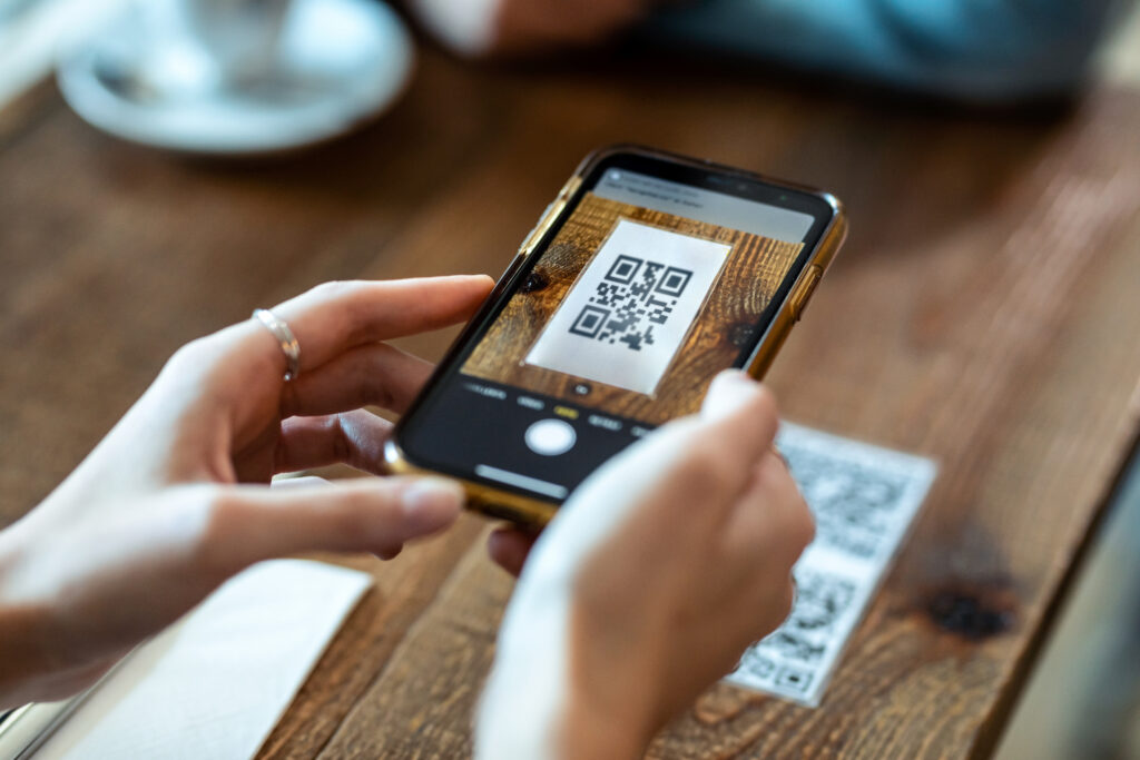 woman hands using the smart phone to scan the qr code to select food menu in the restaurant.